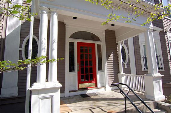 Front view of a house with a red door and white columns.