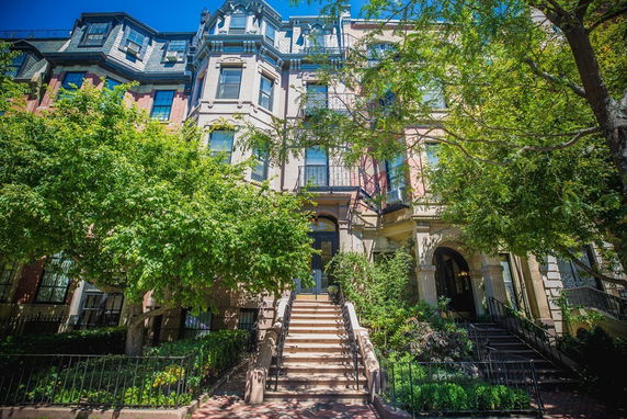 Front view of a multi-story townhouse with ornate architectural details and a central entrance staircase.