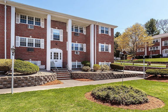 Front view of a two-story brick building with white columns and symmetrical window placement.