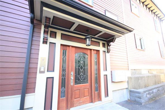 Front view of a building with a decorative wooden door and glass panels.