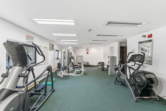 Room with various gym equipment and exercise machines.