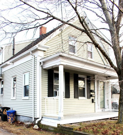 Front view of a two-story house with a covered porch and white siding.