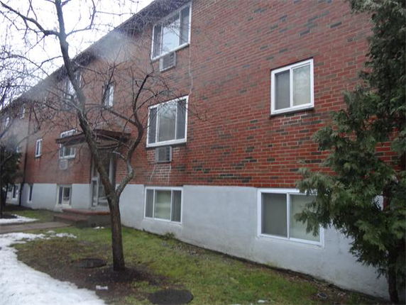 Front view of a brick building with multiple windows and a small entrance.