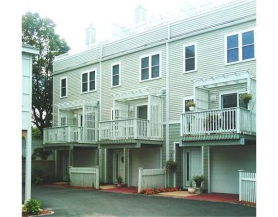 Front view of a multi-story townhouse complex with garages and balconies.