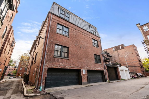 Front view of a multi-story brick building with multiple garages.