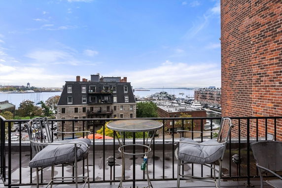 Panoramic view of a balcony overlooking buildings, water, and boats.