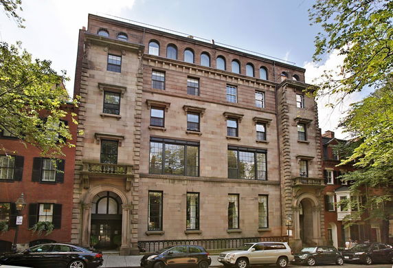 Front view of a multi-story building with arched windows and ornate detailing.