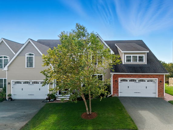 Front view of a house with attached double garages and gabled roof.