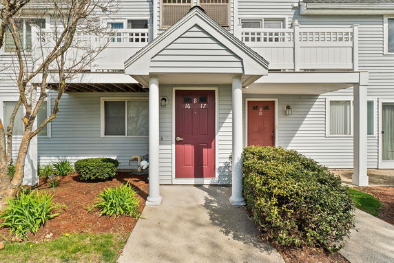 Front view of a residential building with multiple entries and red doors.