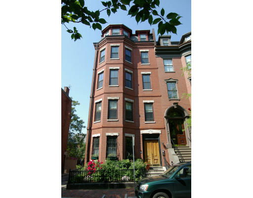 Front view of a multi-story brick building with large windows.