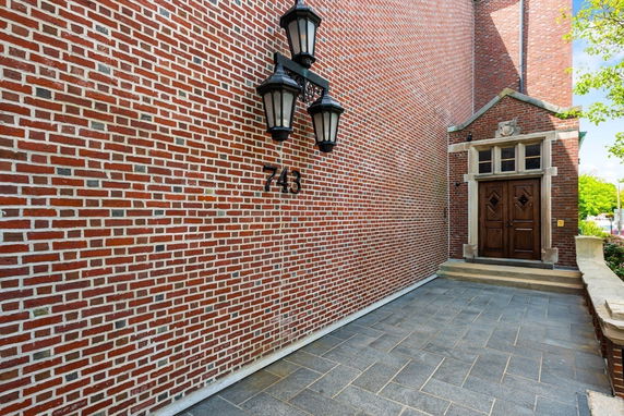 Front view of a building with brick exterior and a wooden door.
