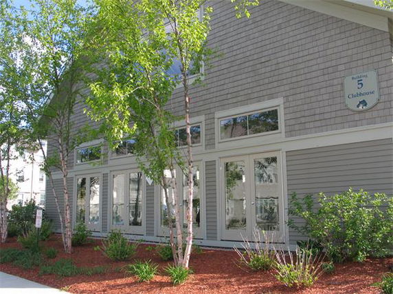 Front view of a clubhouse building with large windows and shingle siding.