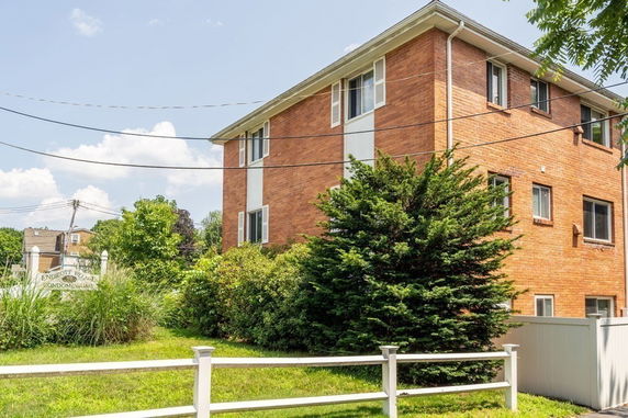 Front view of a multi-story brick condominium building.