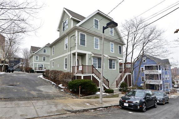 Front view of a multi-story house with a porch and steps leading to the entrance.