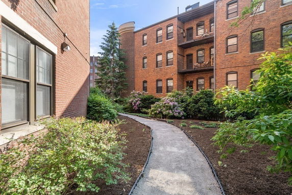 View of brick apartment building with multiple floors and balconies.