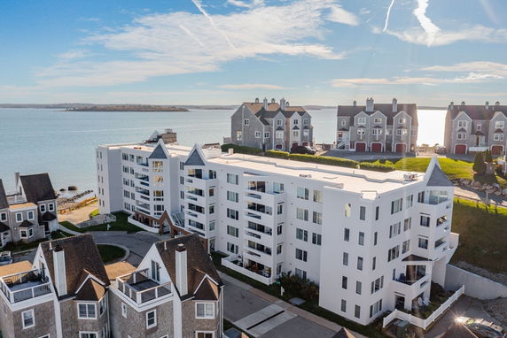 Front view of a multi-story white building near waterfront.