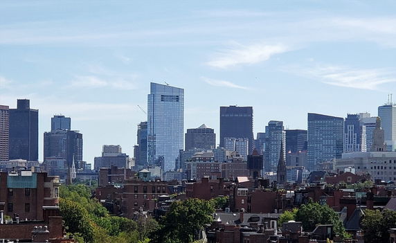 Panoramic view of a city skyline with multiple tall buildings and a clear sky.