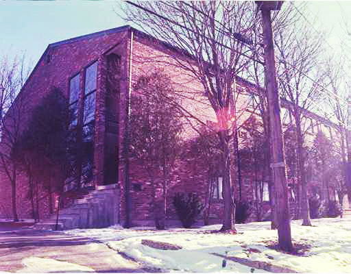 Front view of a large brick building with multiple windows.