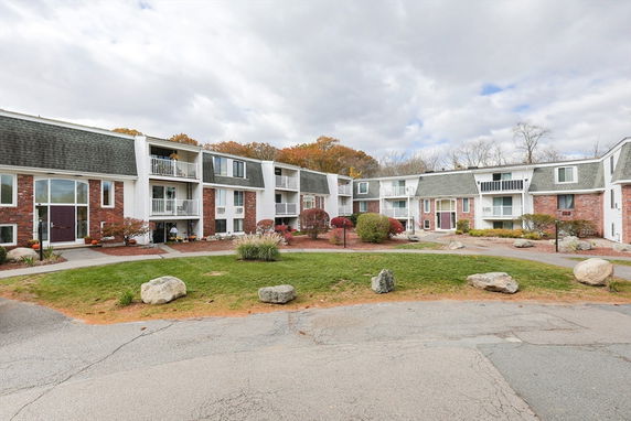Front view of a multi-story apartment building with brick and siding exterior.