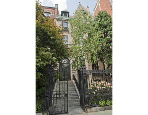 Front view of a multi-story building with a gated entrance and staircase.