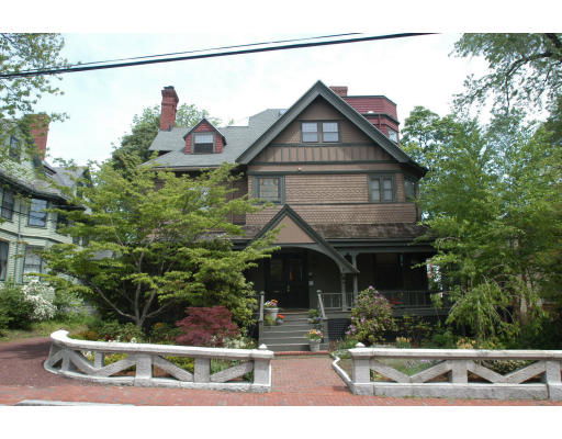 Front view of a multi-story house with gabled roof and porch.