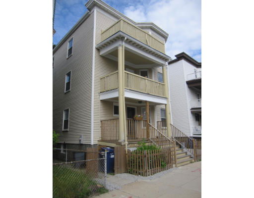 Front view of a three-story house with balconies and a small entrance porch.