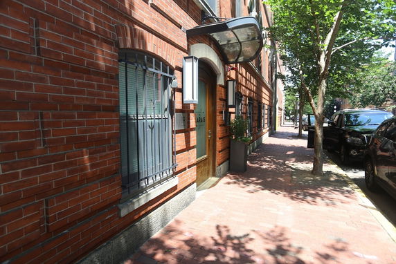Front view of a brick building with arched windows and a glass door entrance.