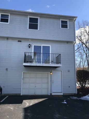 Front view of a two-story house with a small balcony and garage.