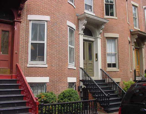 Front view of a multi-story brick townhouse.