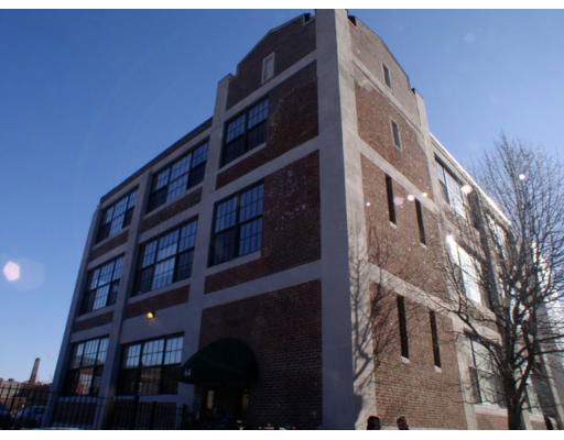 Front view of a multi-story brick building with large windows.