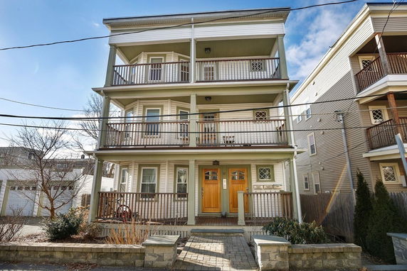 Front view of a three-story residential building with balconies on each level.