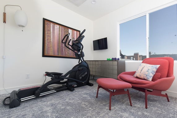 Room with exercise equipment and seating area.
