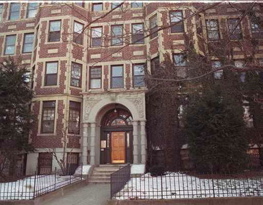 Front view of a brick apartment building with a central entrance.