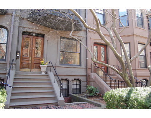 Front view of townhouses with stairs leading to the entrances.