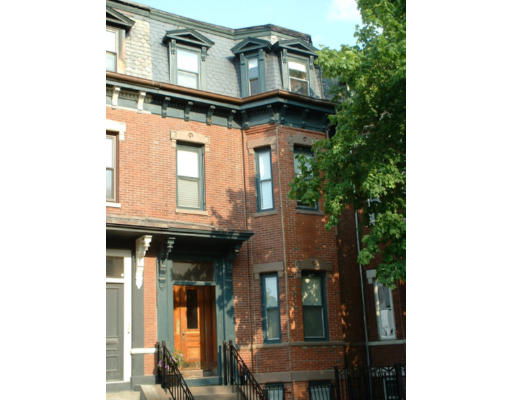 Front view of a multi-story brick house with a prominent entrance.