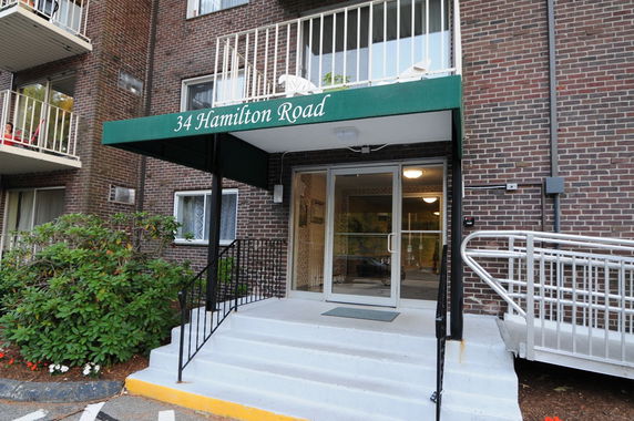 Front view of a multi-story brick building with a green canopy over the entrance.