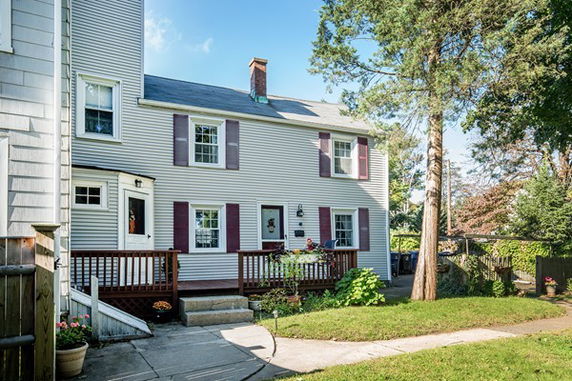 Front view of a two-story house with white siding and red shutters.