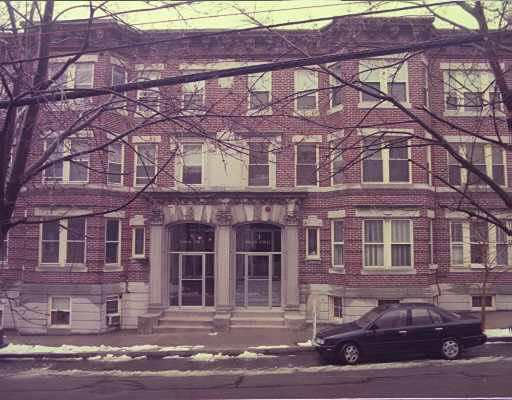 Front view of a multi-story brick apartment building.