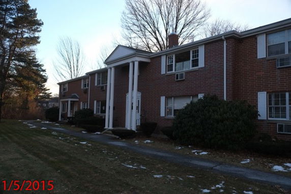 Front view of a two-story brick residential building with columns.