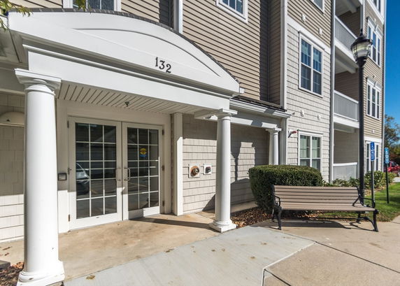 Front view of a multi-story building with an entrance featuring columns and double doors.