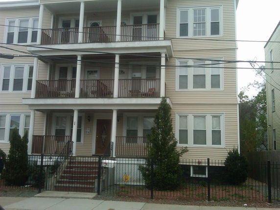Front view of a multi-story residential building with balconies.