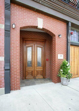 Front view of a building with a brick exterior and a wooden double door.