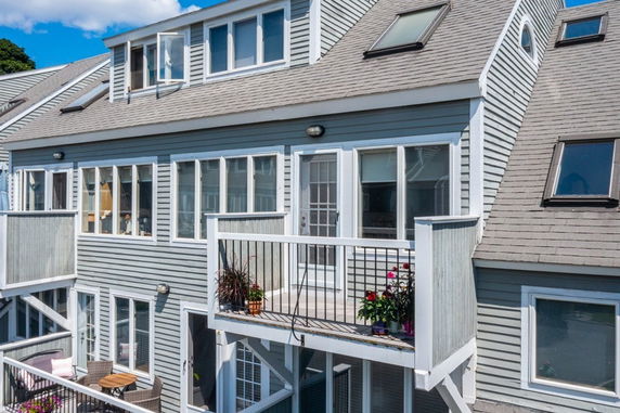 Front view of a multi-story house with balconies and skylight windows.