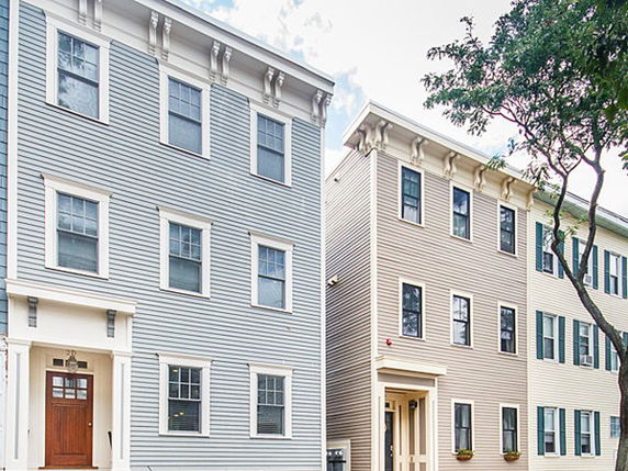 Front view of multi-story houses with similar architectural design.