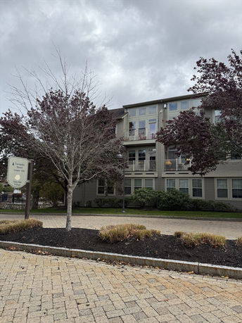 Front view of a multi-story building with balconies and large windows.