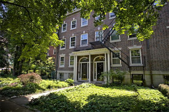 Front view of a brick building with arched entrances and multiple windows.