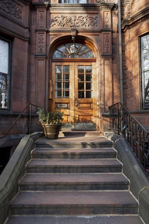 Front view of a traditional building with ornate wooden door and stone steps.