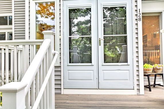 Front view of a building entrance with double glass doors and railing.