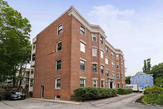 Front view of a multi-story brick building with multiple windows.