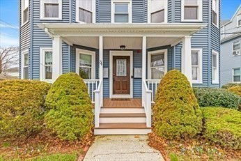 Front view of a two-story house with a porch and blue siding.